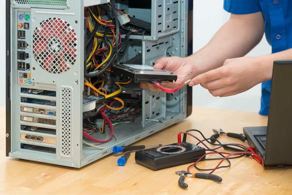 Technician repairing a desktop PC's internal components at Cadlinc Infotech