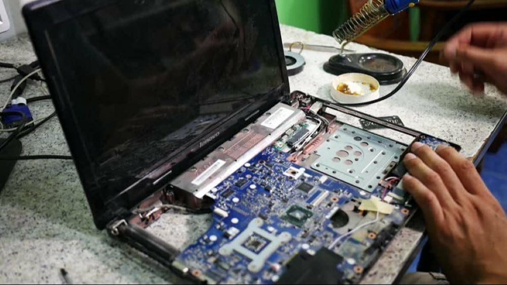 Technician replacing internal components on an open laptop at Cadlinc Infotech